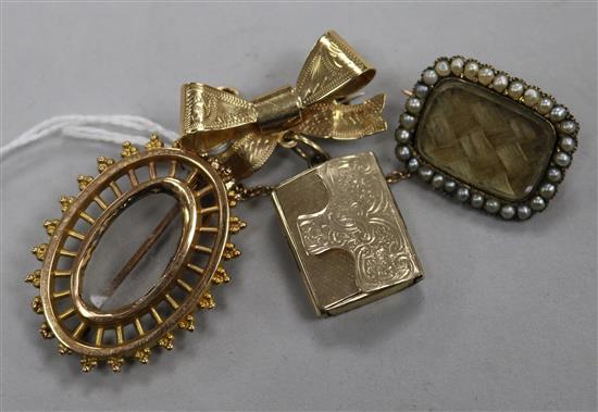 A 15ct gold oval brooch, a pendant locket brooch and an Edwardian yellow metal mourning brooch.